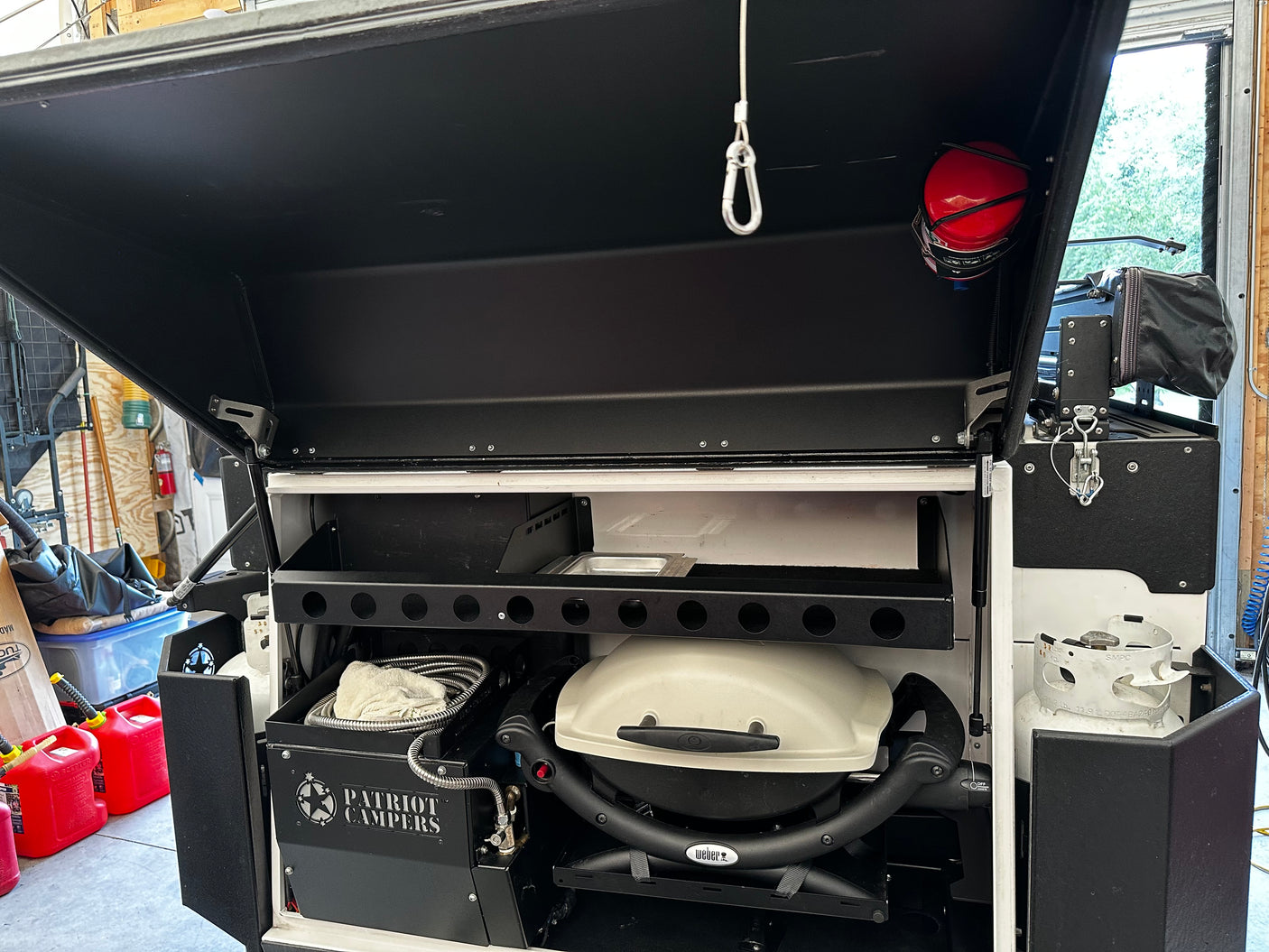 Rear compartment with swing-out Weber Q1000 BBQ and two propane tanks