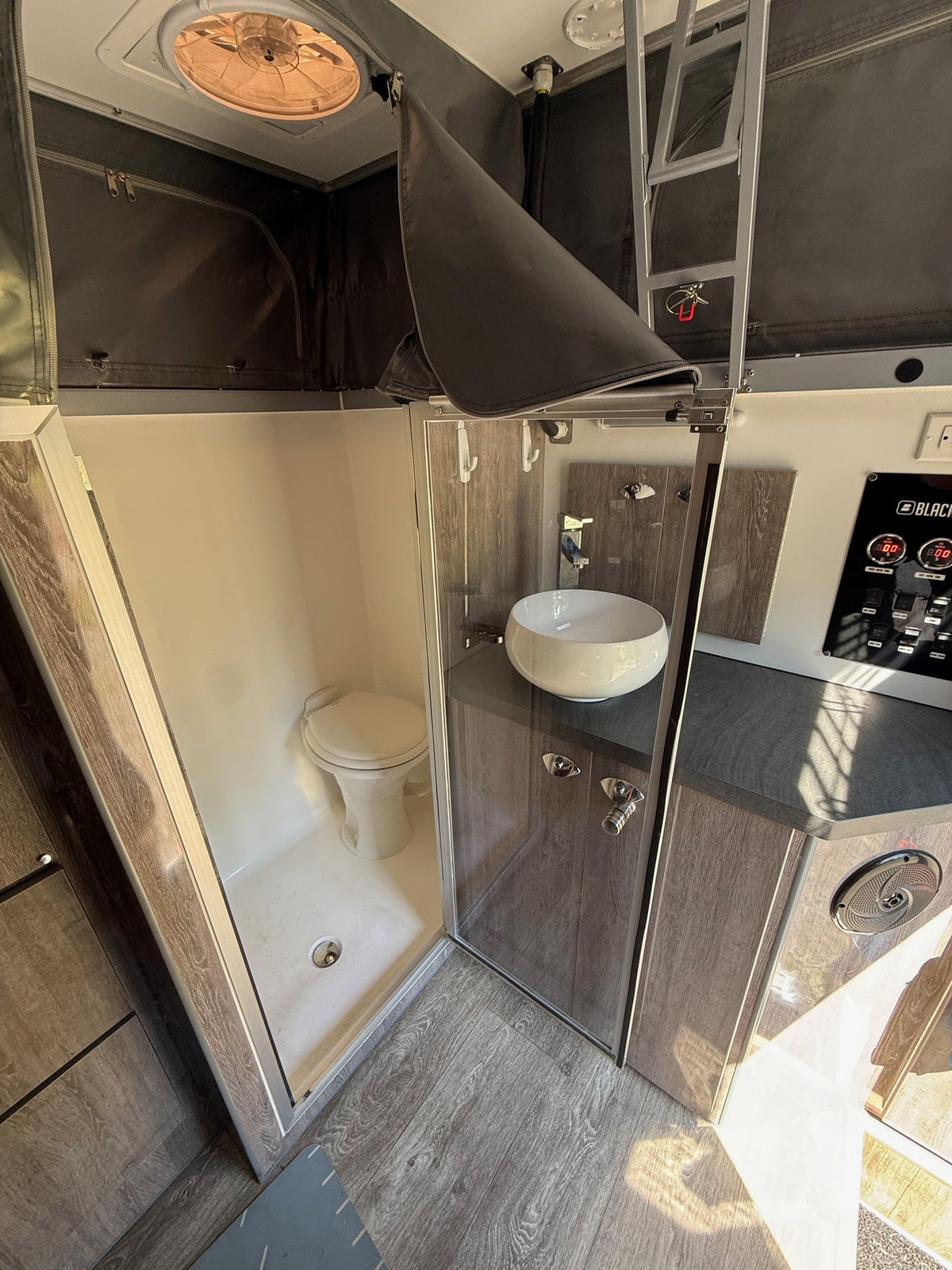 Wet bath with the glass shower enclosure, Dometic RV toilet, vessel sink vanity and roof fan — photo 16