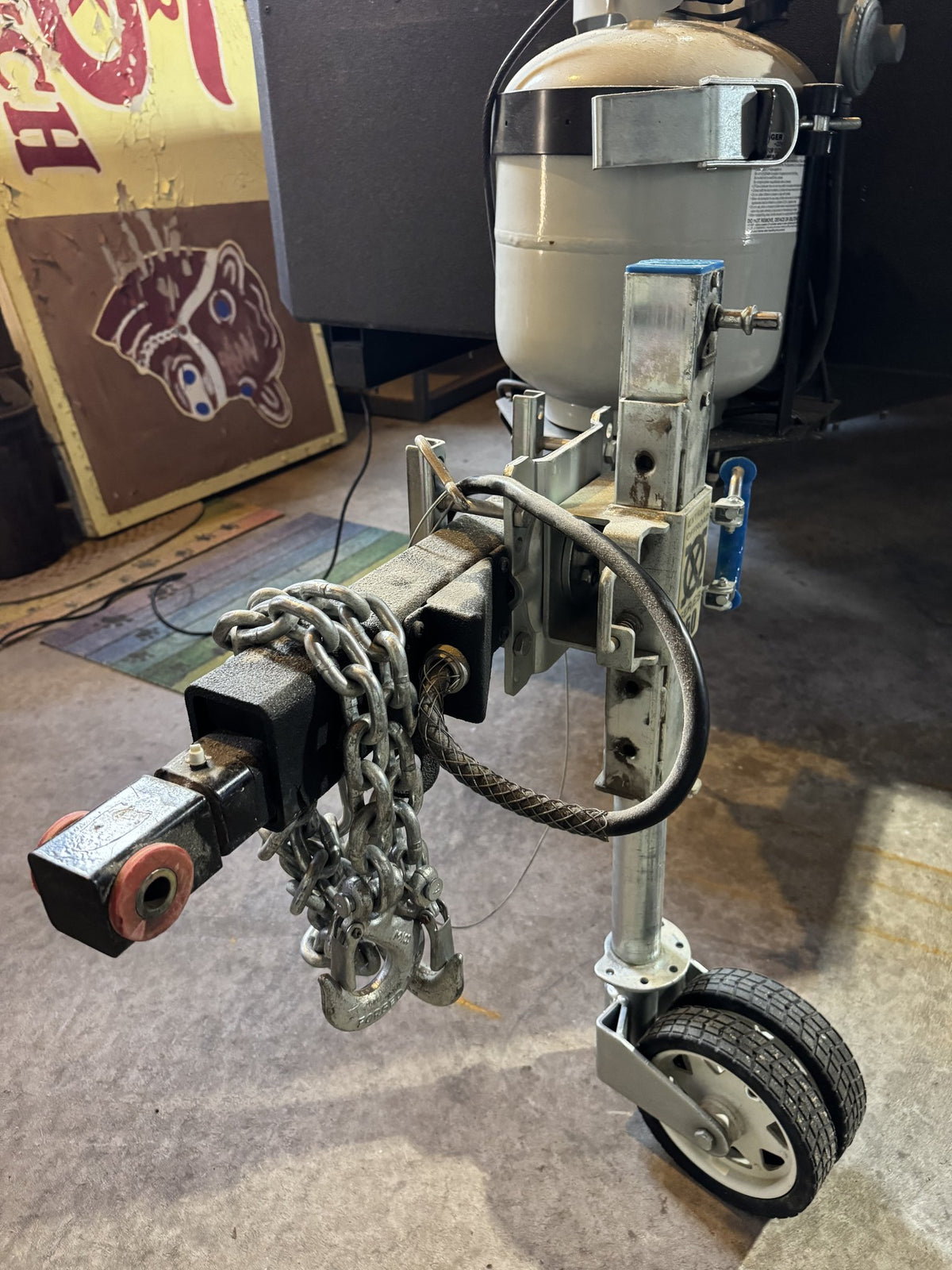 Trailer tongue with the coupler, safety chains, swing-up jack wheel and lockable propane tank — photo 32