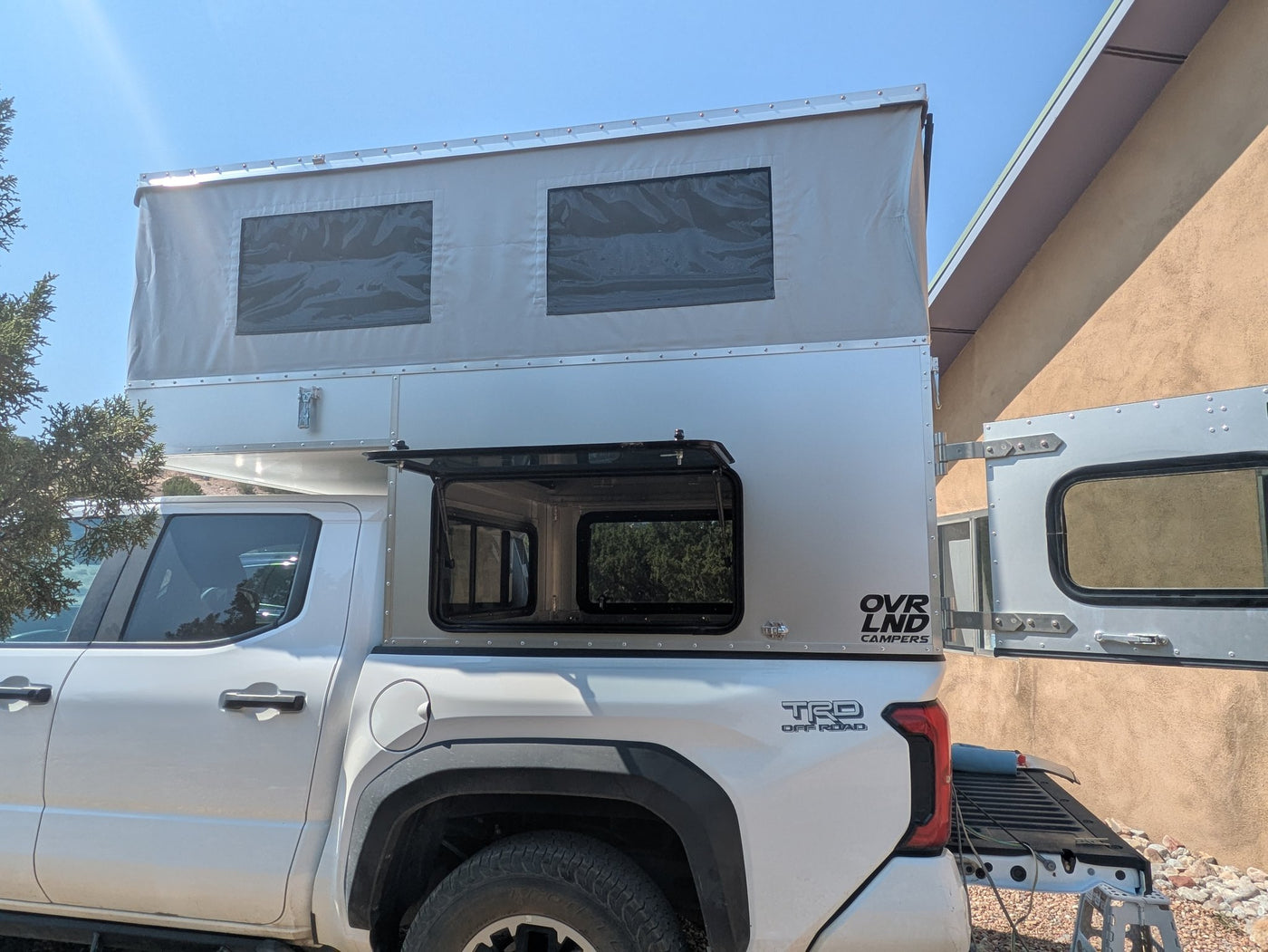 Full passenger-side profile of the camper with the roof up and side windoor visible — photo 4
