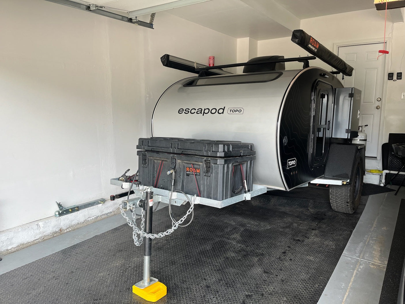 Escapod TOPO front three-quarter view with ROAM awning, roof rack and tongue storage box