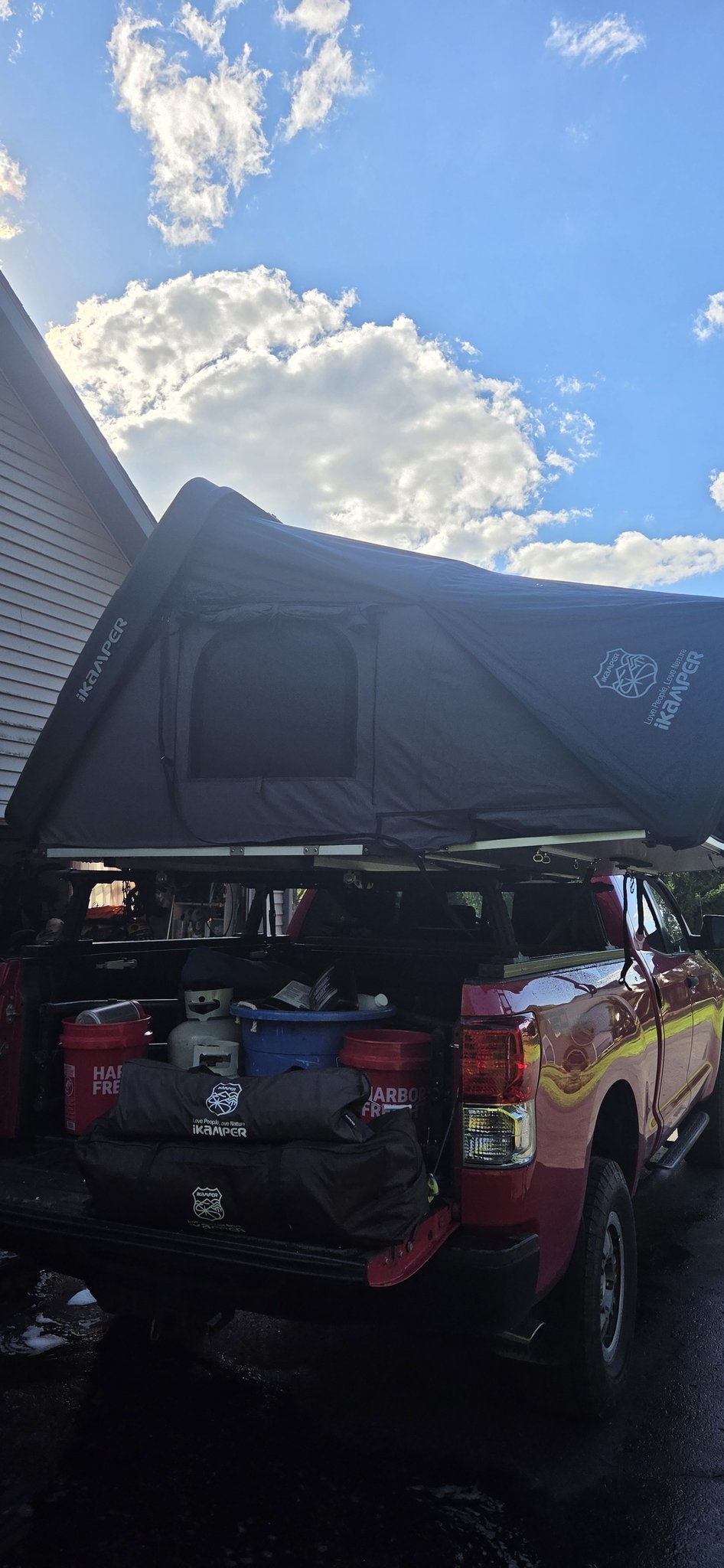 Skycamp 3.0 deployed over the truck bed, rear three-quarter view showing the open clamshell and awning line — photo 3