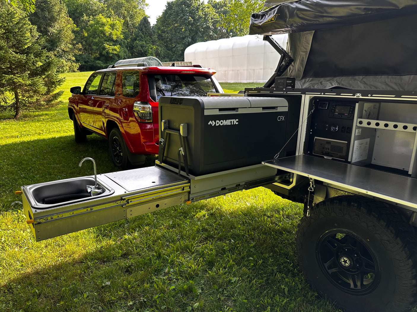 Outdoor kitchen and sink area with tow vehicle in background