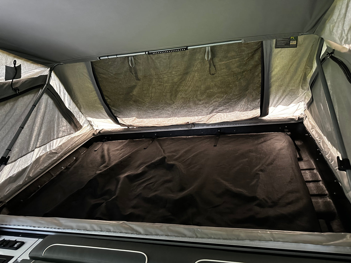 Interior fold-out queen bed under the tent canopy