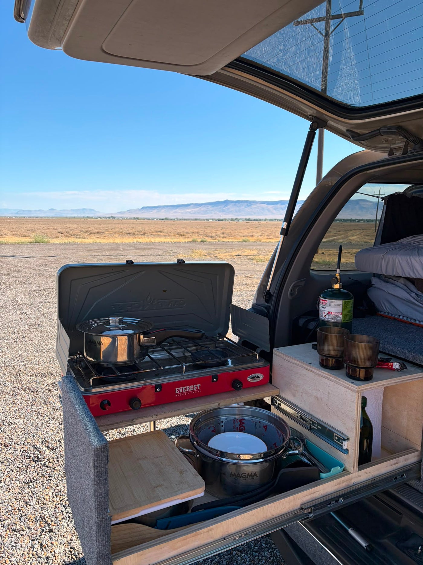 Pull-out cooking surface extended with an Everest two-burner camp stove, Magma cookware, cutting board and propane bottle — photo 8