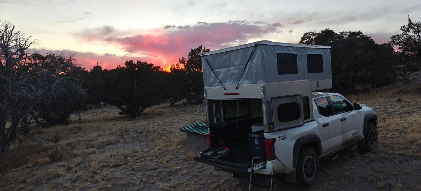 Evening camp with the barn doors open and the tailgate down under a pink sky — photo 10