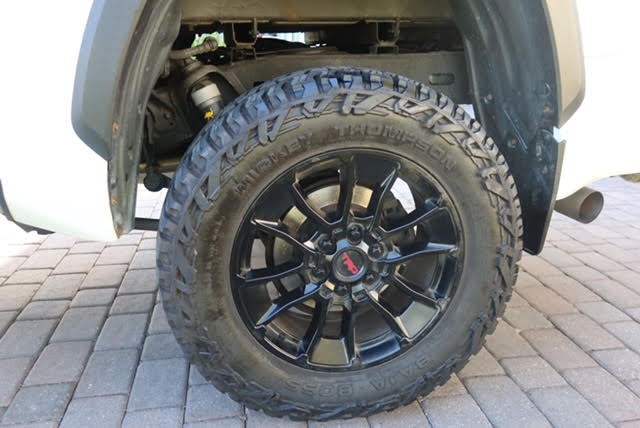 Close-up of one 35x12.5R20 Mickey Thompson Baja Boss A/T tire on a black TRD alloy wheel, tread clearly visible with plenty of life left — photo 15