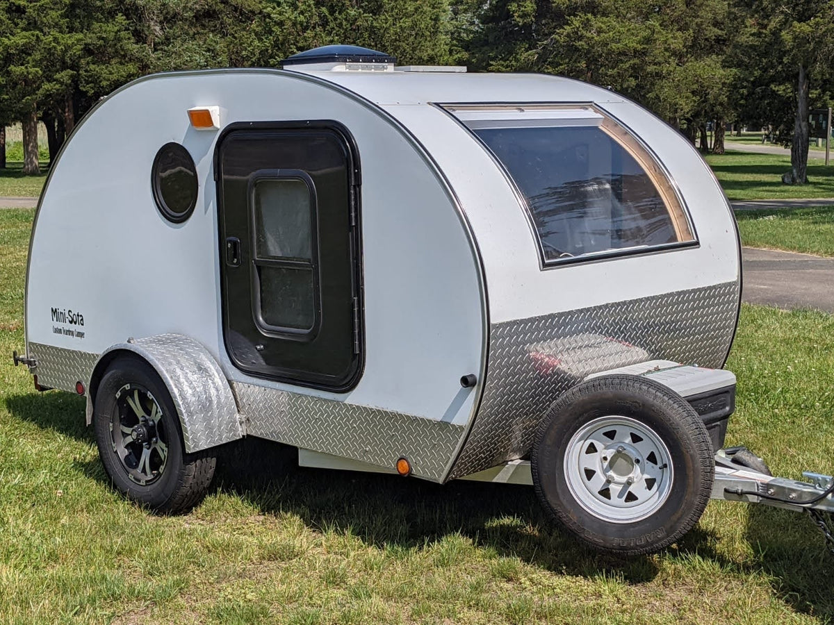 White Mini-Sota teardrop RV rental with diamond plate trim