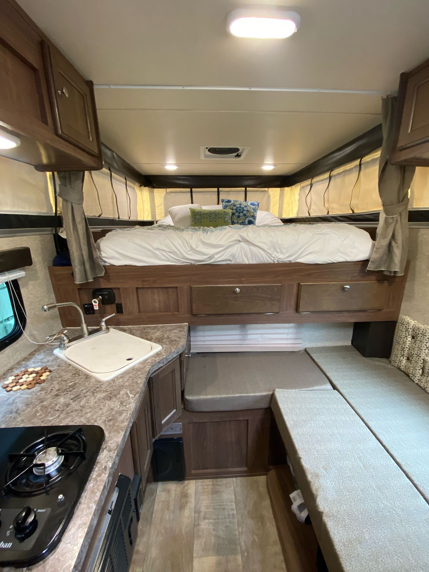 inviting bed inside a pop-up camper. White sheets