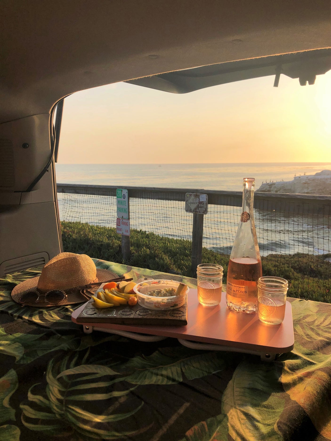 Enjoy a beautiful sunset picnic from your RV rental, with rosé wine, fruit, and dip, overlooking the ocean.