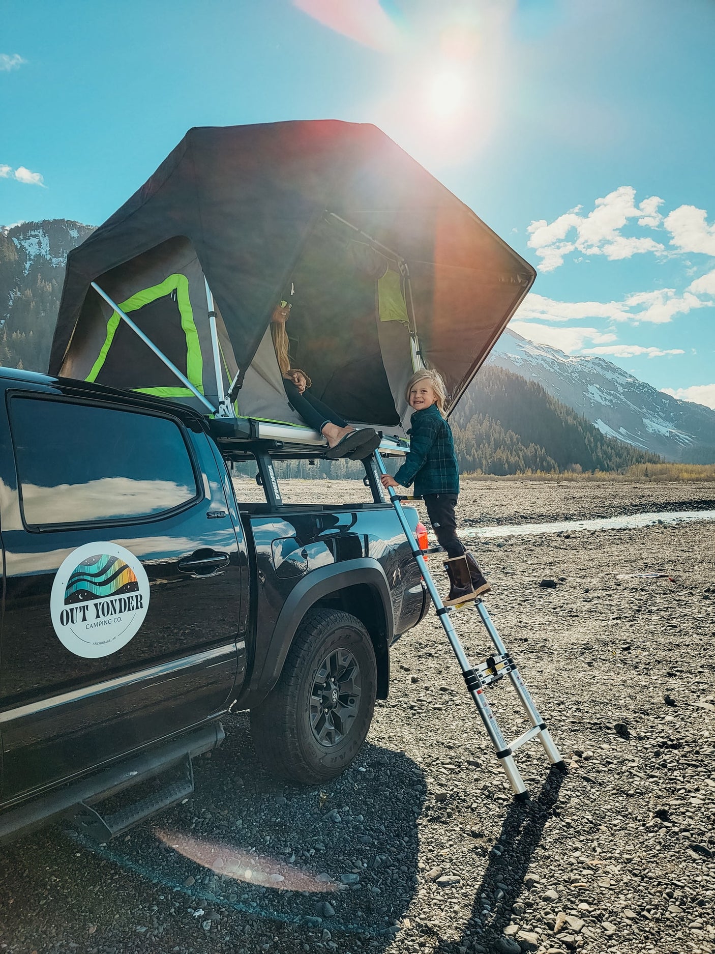 Family enjoying truck camping with a rooftop tent. An RV rental alternative for mountain adventures.