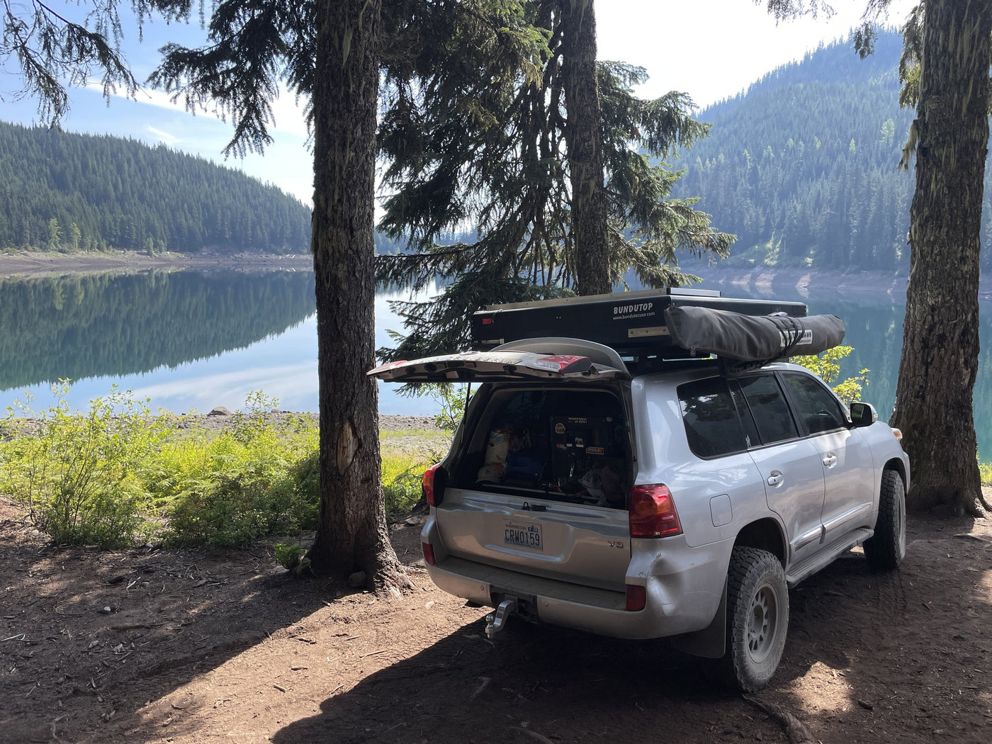 Vehicle with the rooftop tent closed, parked lakeside — photo 7