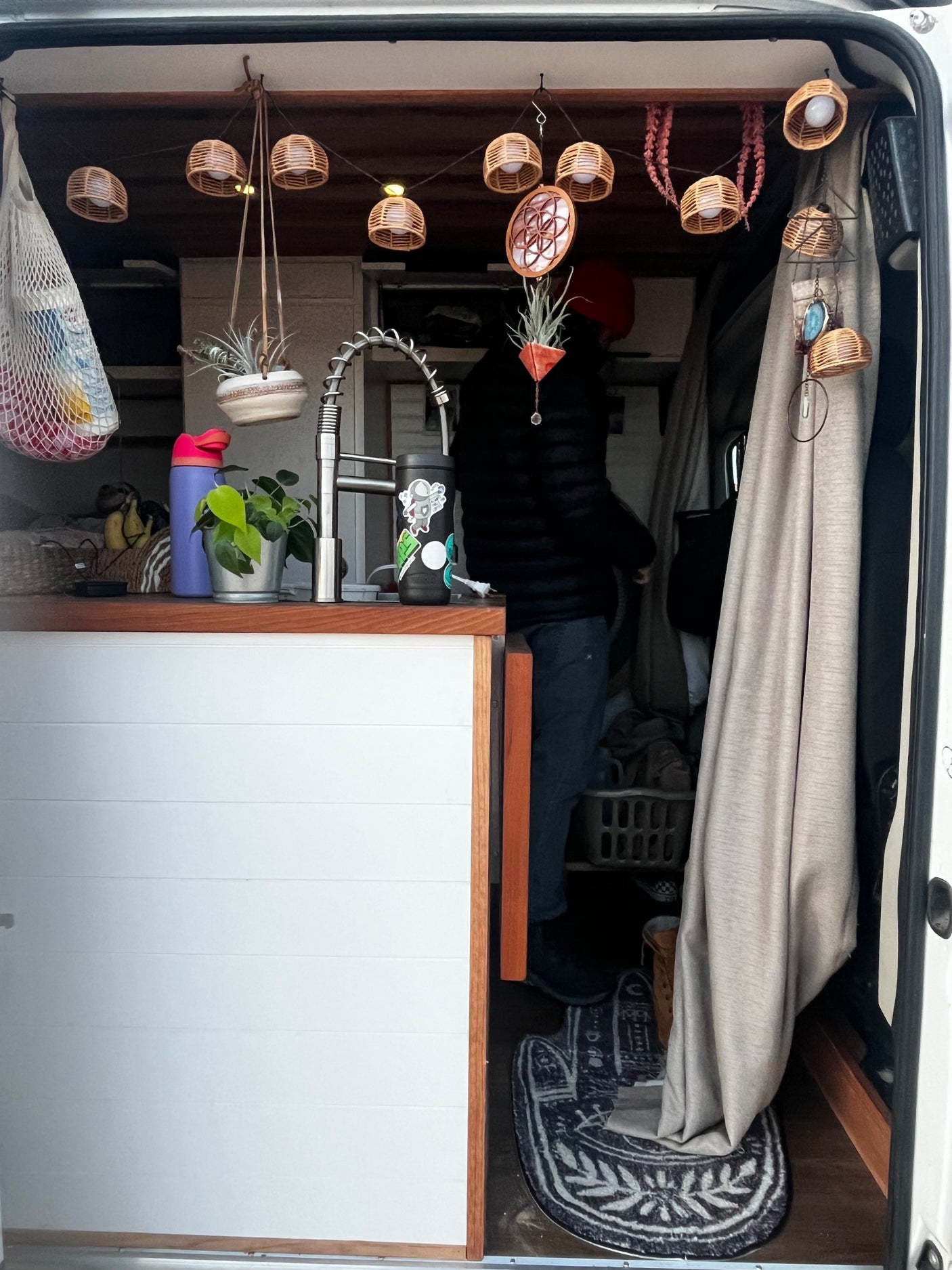 Cozy RV rental interior: a charming living space with kitchen, unique decor, and a person inside.
