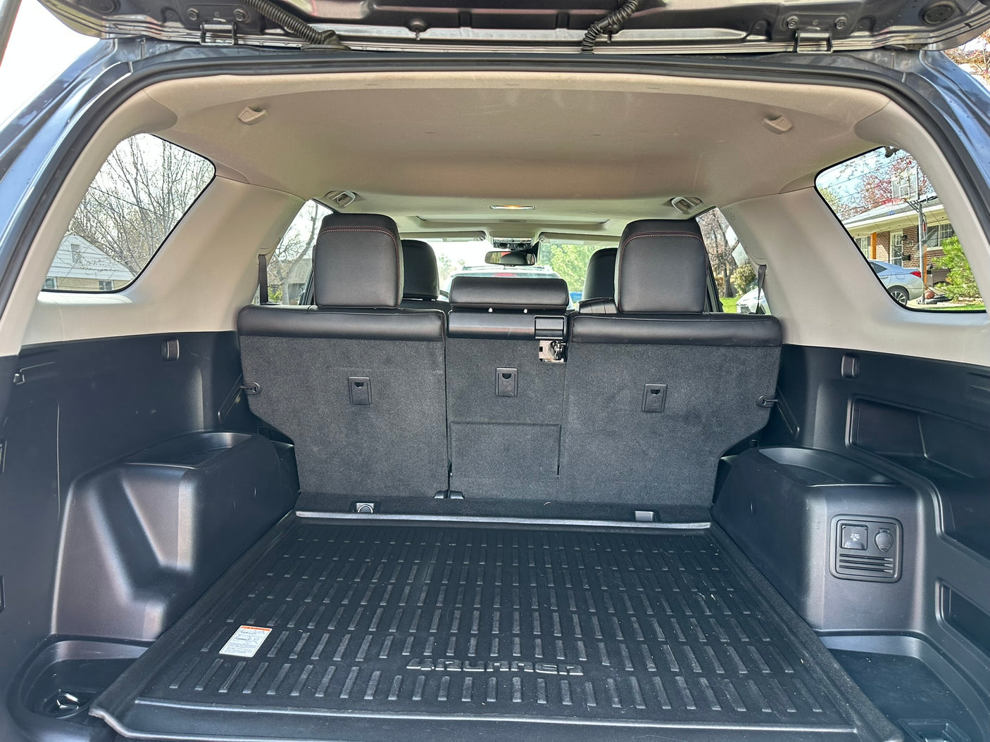 Spacious Toyota 4Runner SUV cargo area, ready for an rv rental. Features upright seats, floor mat, and power outlets.