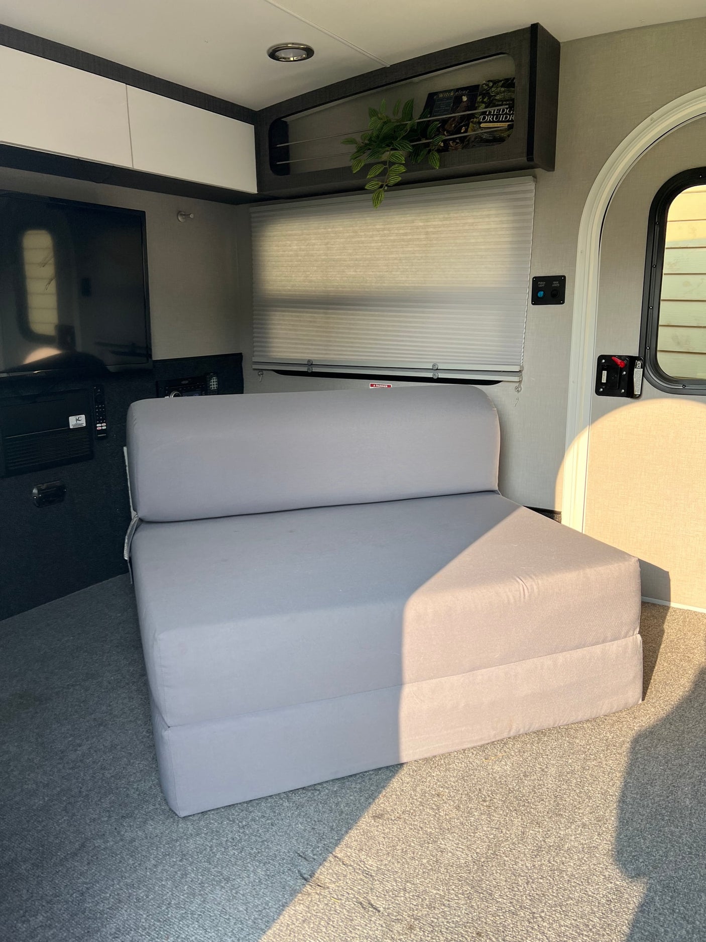 illuminated storage with blue accent lighting.|Practical RV rental storage: an open cabinet reveals neatly stacked clear containers with towels