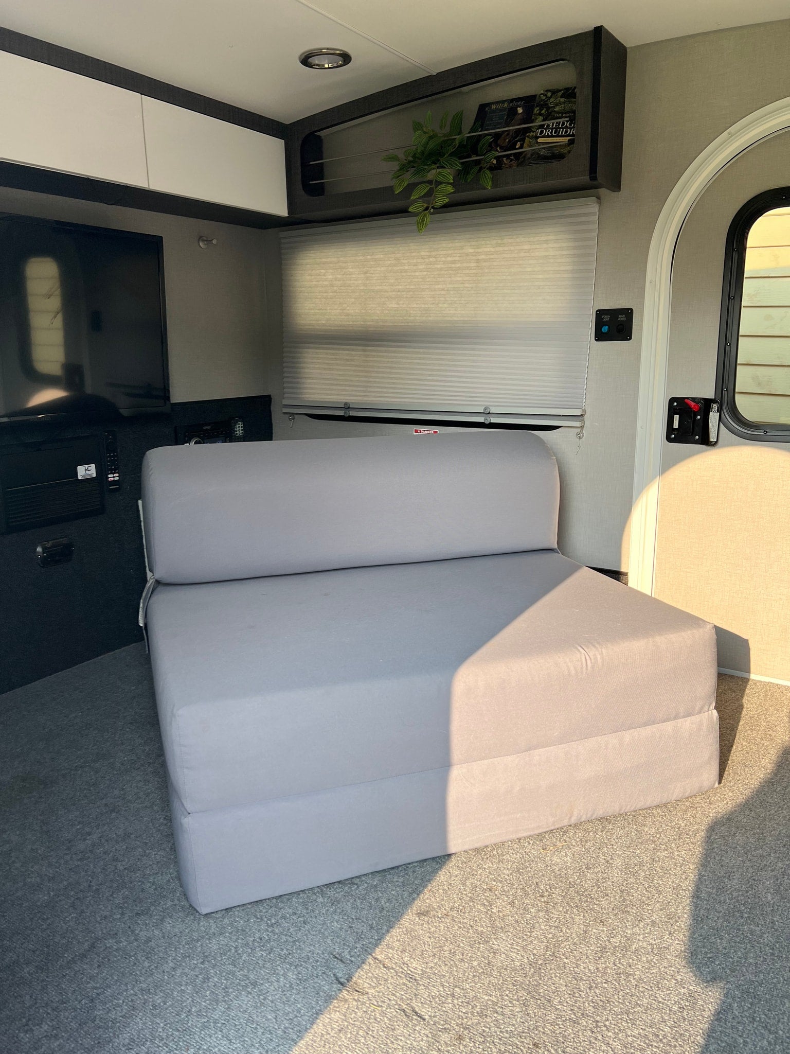 illuminated storage with blue accent lighting.|Practical RV rental storage: an open cabinet reveals neatly stacked clear containers with towels