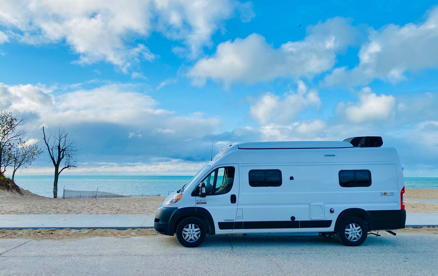 and folding door with a mirror on the left.|Comfy RV rental bedroom with a paw-print pillow
