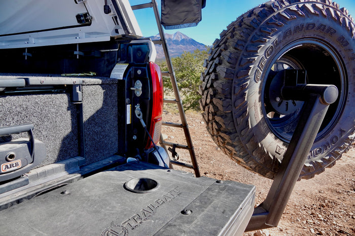 Truck bed with ARB gear, swing-out spare tire, and ladder for an RV rental outdoor adventure.