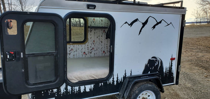 Cozy RV rental camper: custom bear and mountain exterior, warm interior with birch tree & bird wallpaper. Perfect for outdoor adventure.