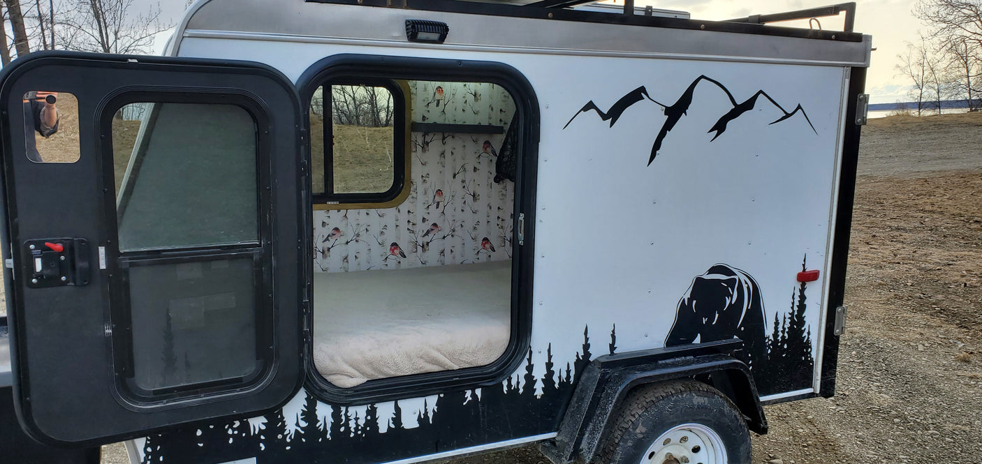 Cozy RV rental camper: custom bear and mountain exterior, warm interior with birch tree & bird wallpaper. Perfect for outdoor adventure.