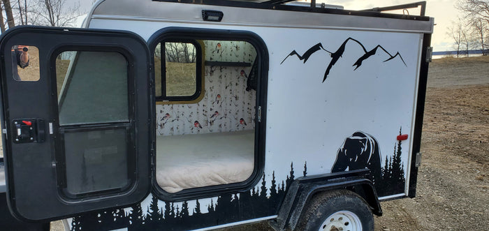 Cozy RV rental camper: custom bear and mountain exterior, warm interior with birch tree & bird wallpaper. Perfect for outdoor adventure.