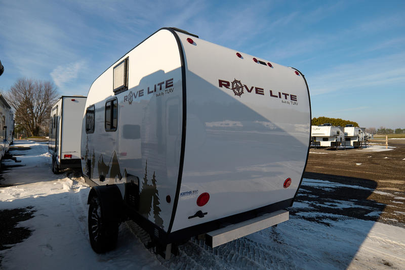 showcased in a snowy lot with other RVs.|This compact wet bath inside an RV rental features a shower