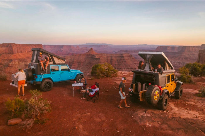 perfect for RV rental adventures.|Friends camping with custom rv rental Jeeps & rooftop tents in a vast desert canyon