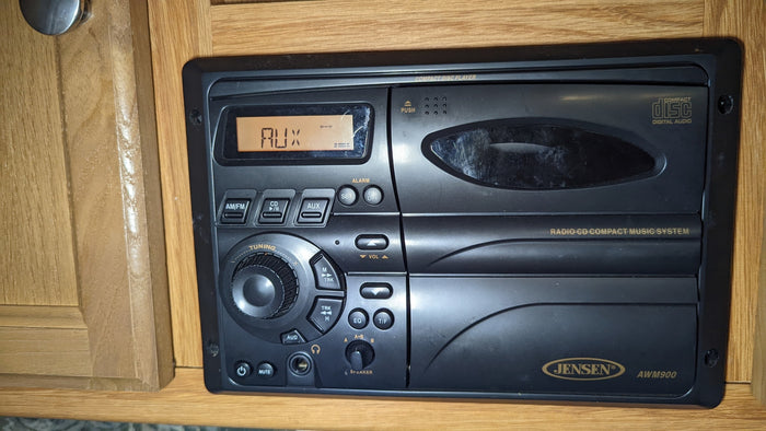Jensen AWM900 RV stereo system, showing AUX mode on the display, a common feature in an RV rental.