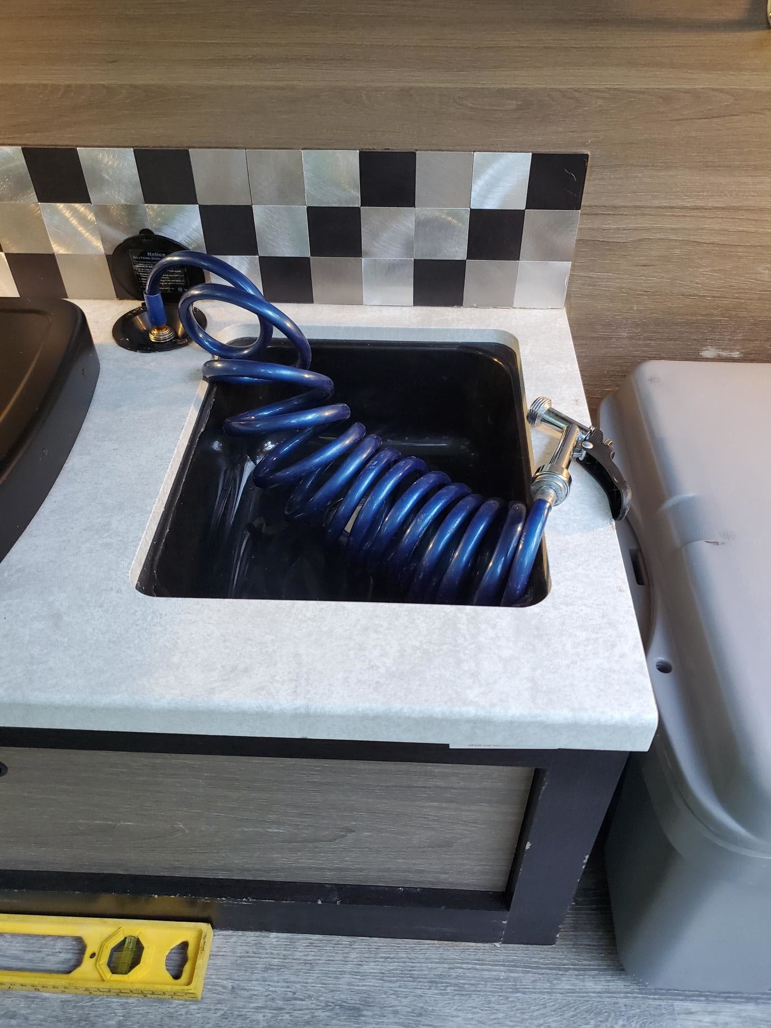 with a blue sleeping bag partly covering the vent.|A gray and black Bushwhacker teardrop RV rental