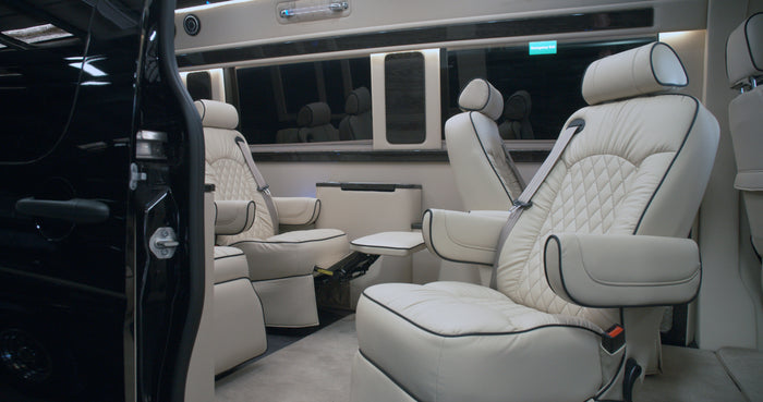 perfect for private travel.|Luxury RV rental interior with plush cream captain's chairs