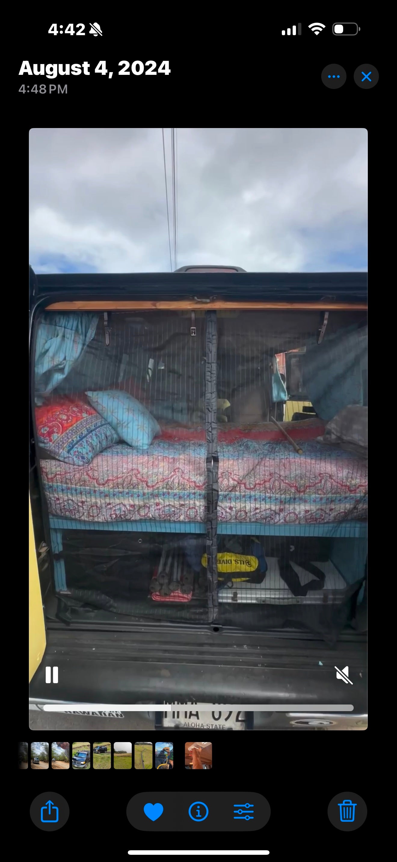 Cozy camper van setup: bed, pillows, and gear storage seen through a mesh screen. Perfect for an rv rental adventure!