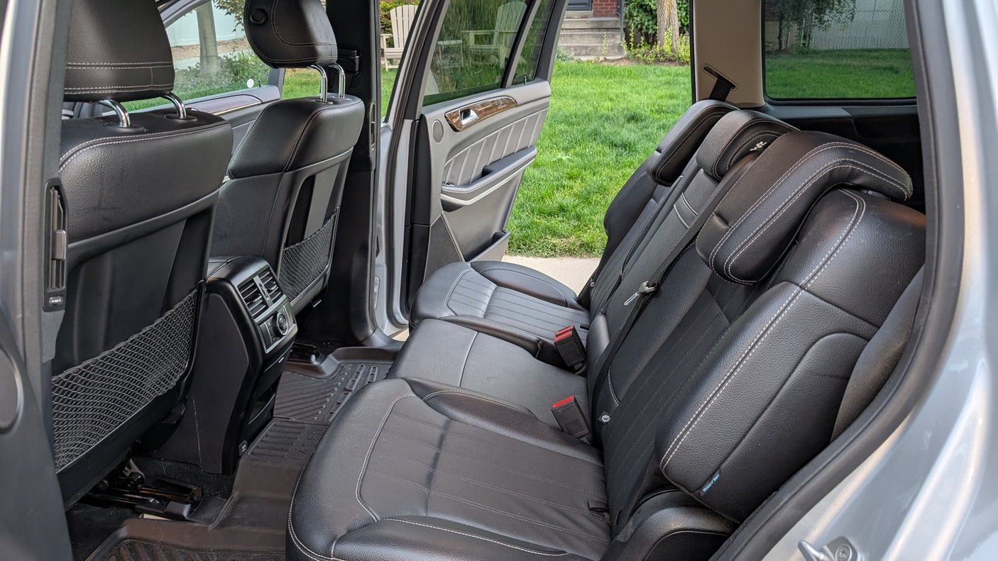 Vehicle interior with spacious black leather second and third-row seats, ideal for comfortable travel with an RV rental.