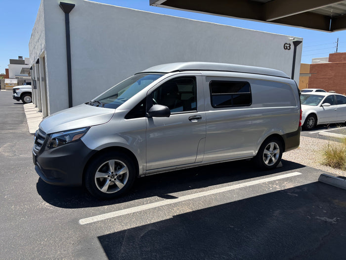 Silver Mercedes-Benz camper van with a pop-top roof, perfect for your next rv rental experience.