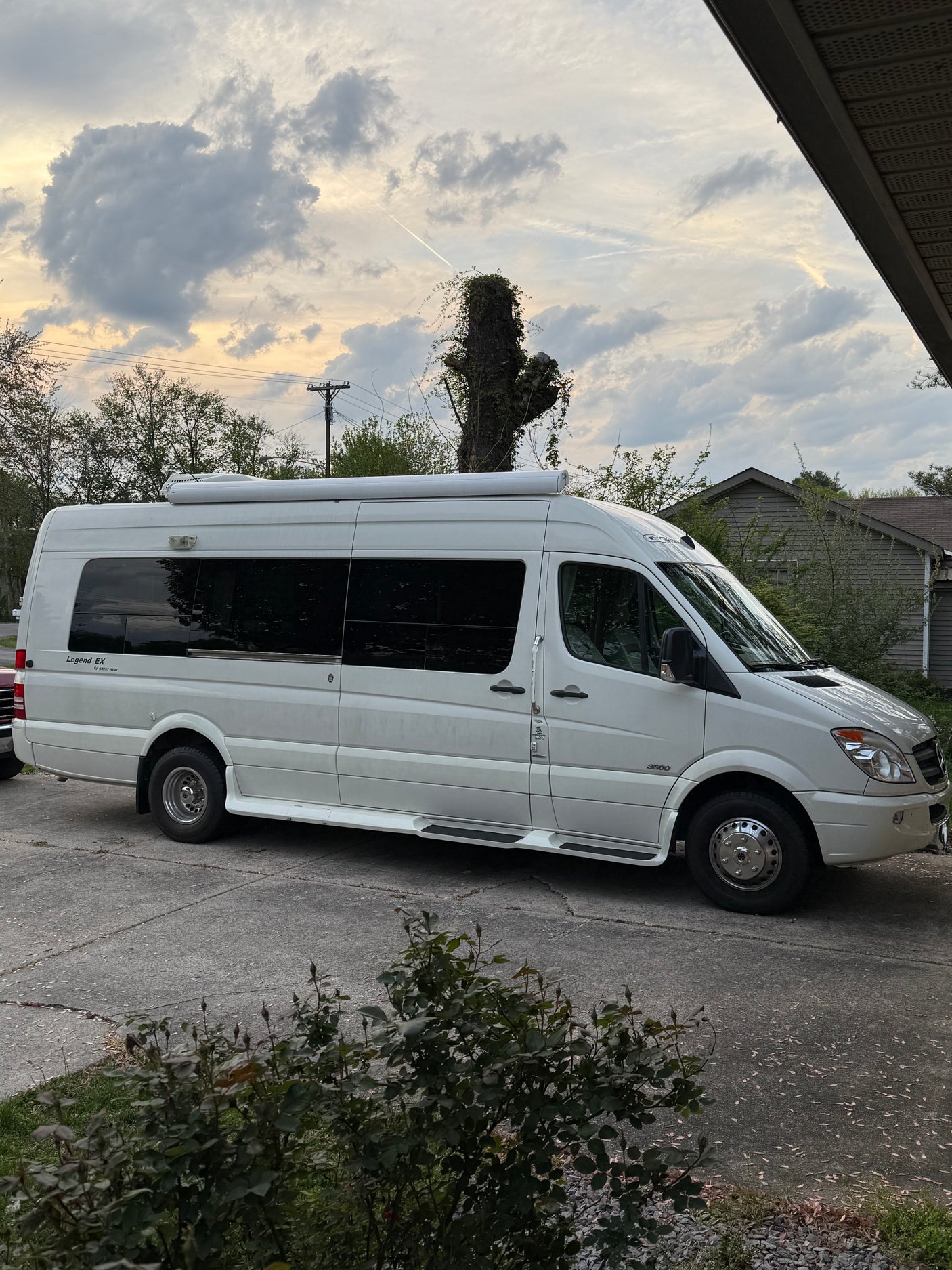 White Mercedes-Benz Sprinter RV rental parked on a concrete driveway