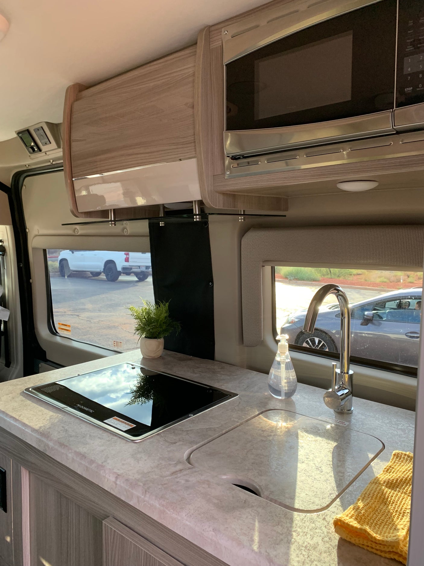 Experience cooking on the go! This RV rental features a compact kitchenette with sink, stovetop, microwave & sunny views.