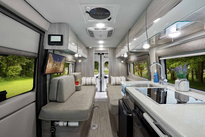 at a campsite with another RV in background. Perfect for road trips.|Explore this modern RV rental's inviting interior: sleek kitchen