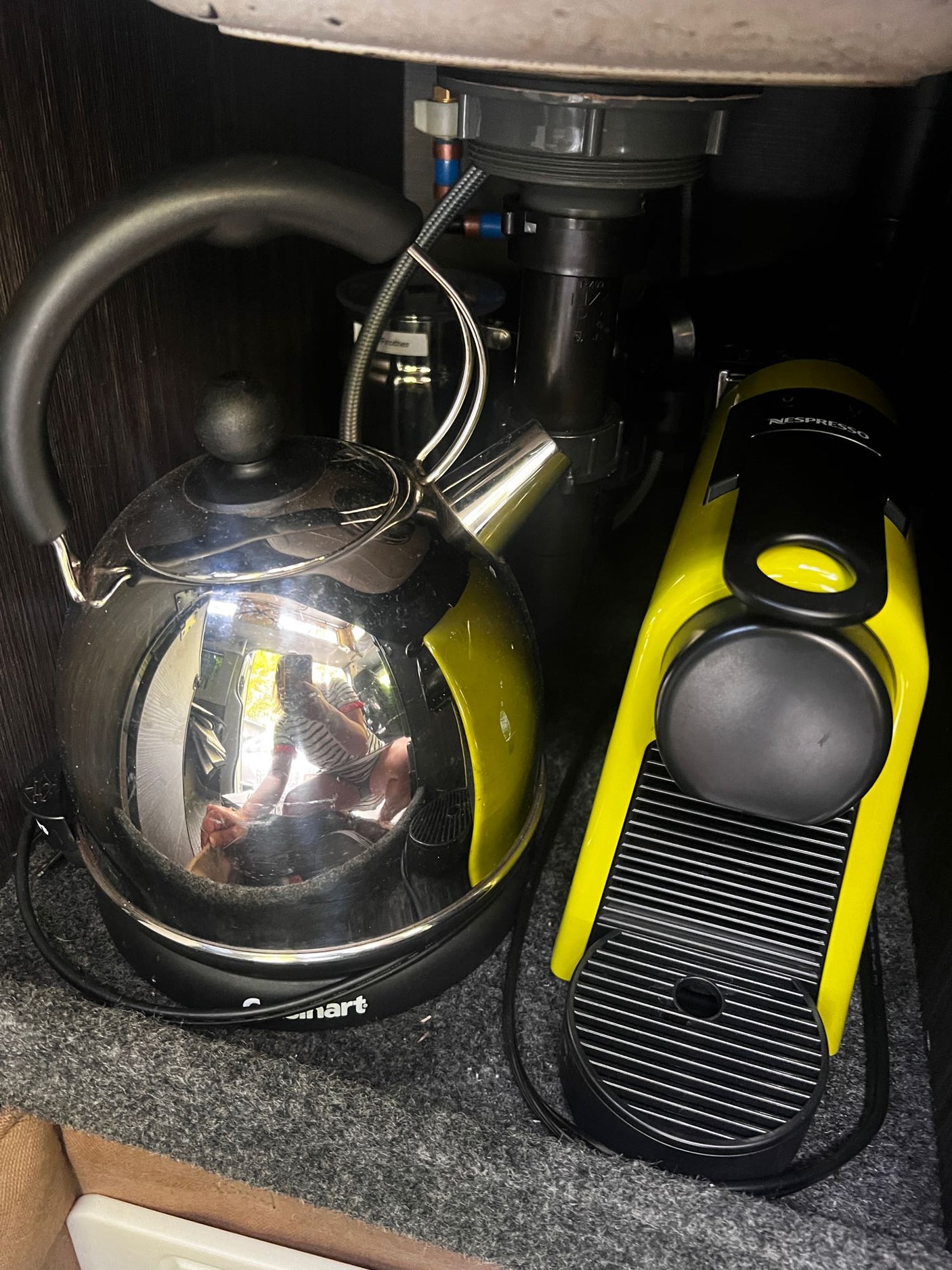 RV rental compact kitchen setup: sleek electric kettle & bright yellow Nespresso machine for your morning brew.