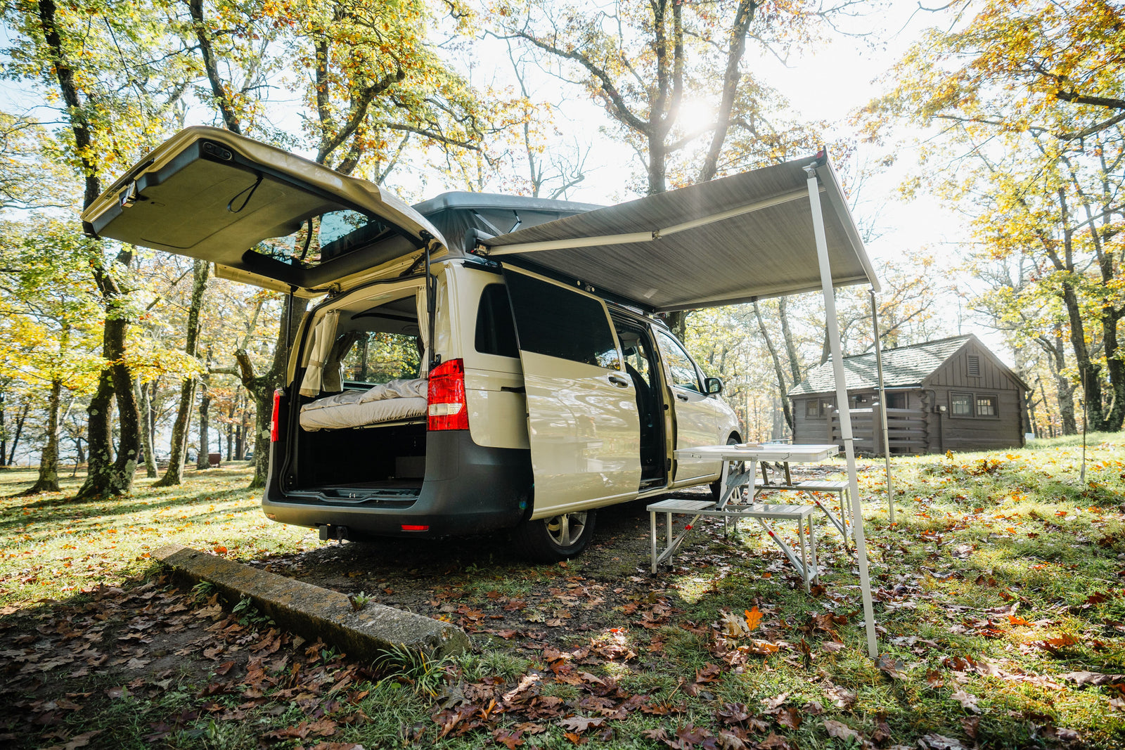 with a grill setup.|RV rental van on a scenic autumn road