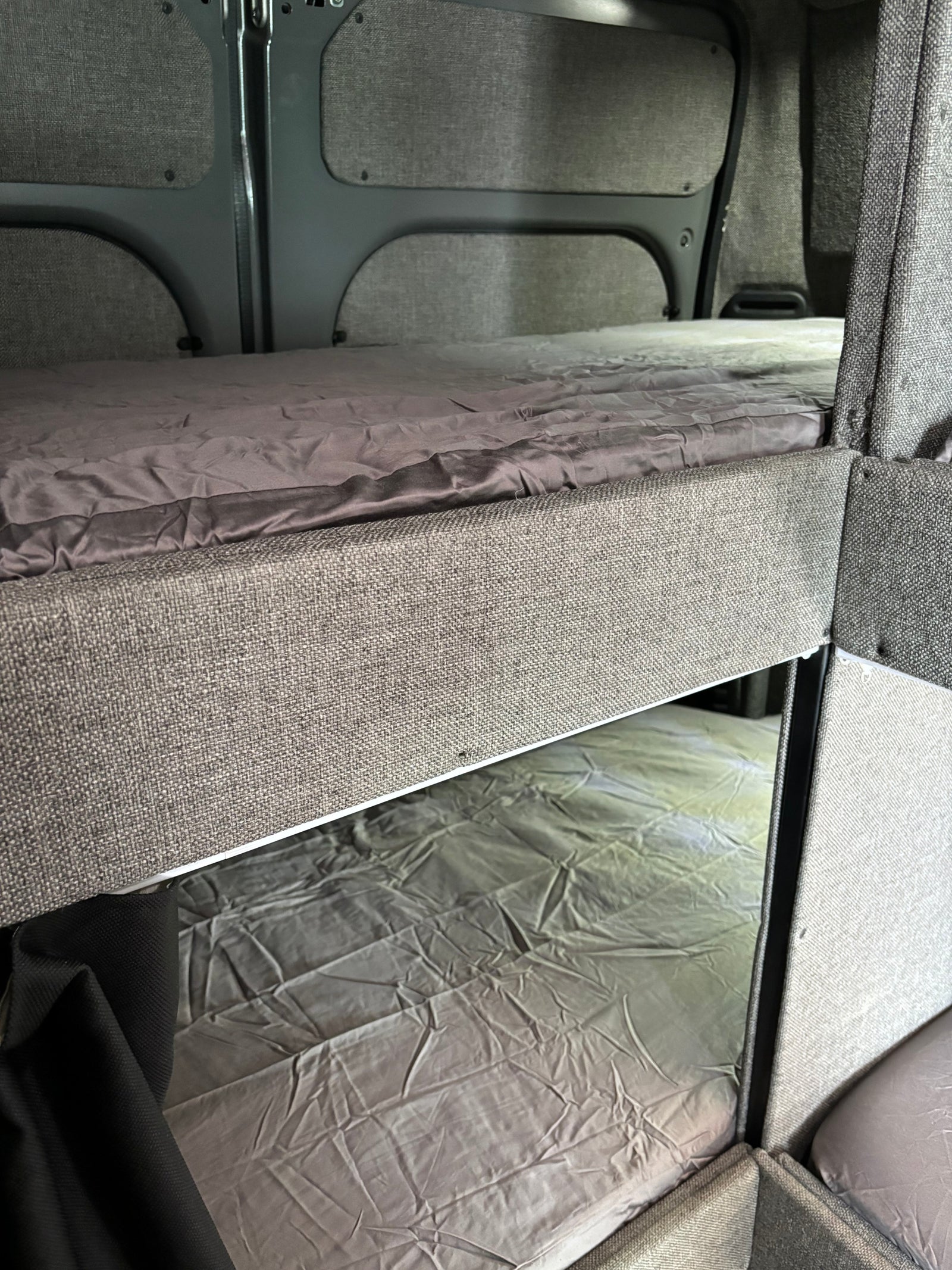RV rental with comfortable bunk beds and grey bedding, perfect for family adventures.