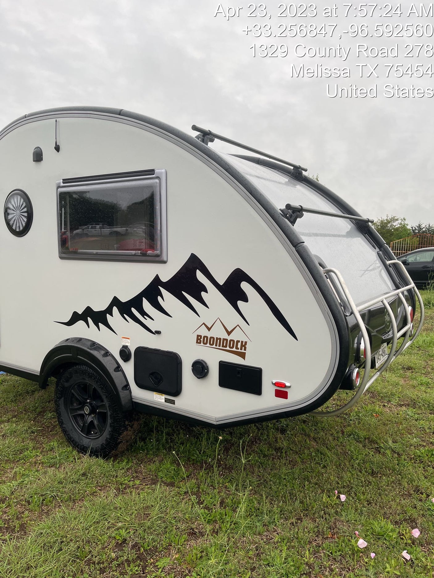 Explore the outdoors with this Boondock teardrop RV rental trailer. A rugged camper ready for adventure, parked on grass.
