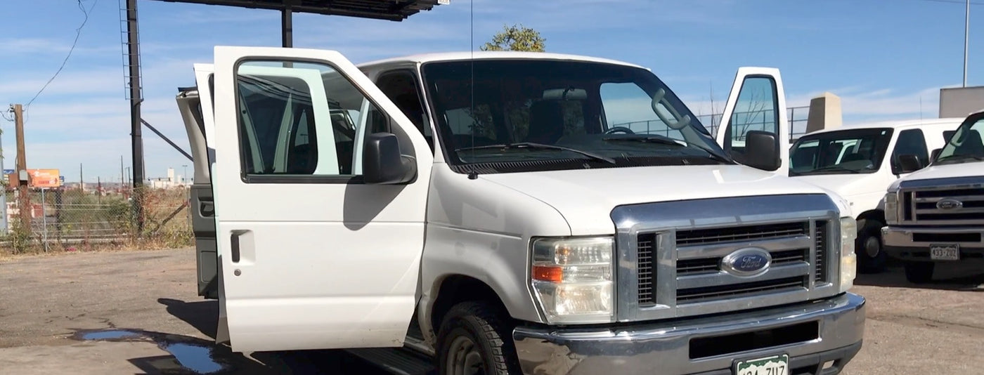 White Ford Econoline van with open doors — photo 1