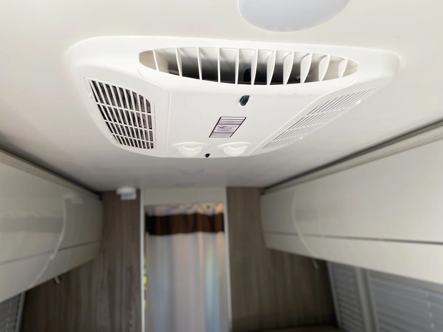 and convertible bed/seating.|Bright rv rental interior: compact kitchen (sink