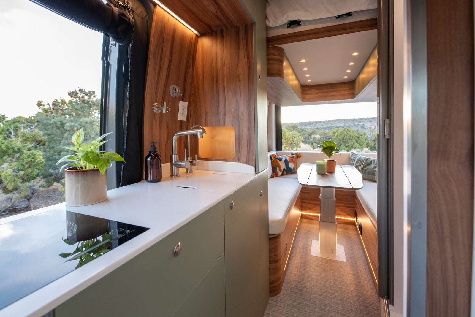 Stylish RV rental interior with a modern kitchen, cozy dining area, and scenic views through the large window.