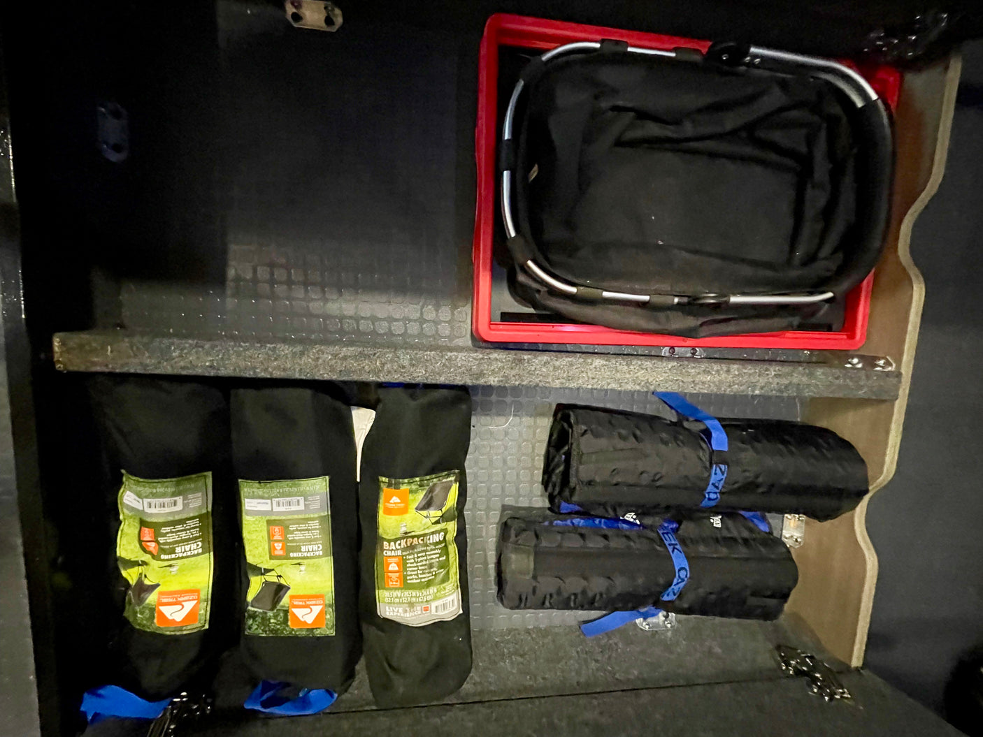 RV rental storage: Organized camping gear with backpacking chairs, a collapsible basket, and rolled items kept tidy for adventure.