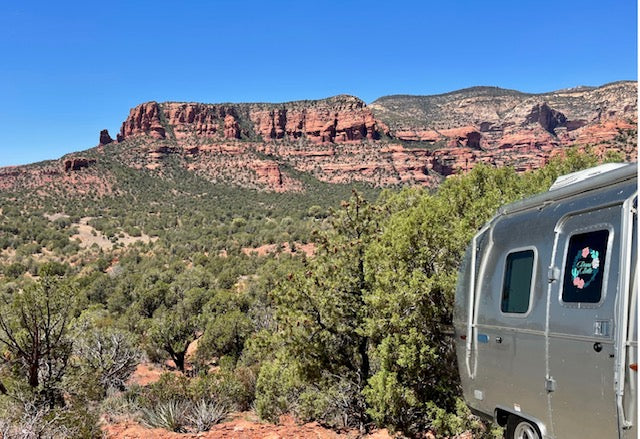 An Airstream RV rental offers breathtaking views of red rock mountains & desert greenery under a blue sky. — photo 5