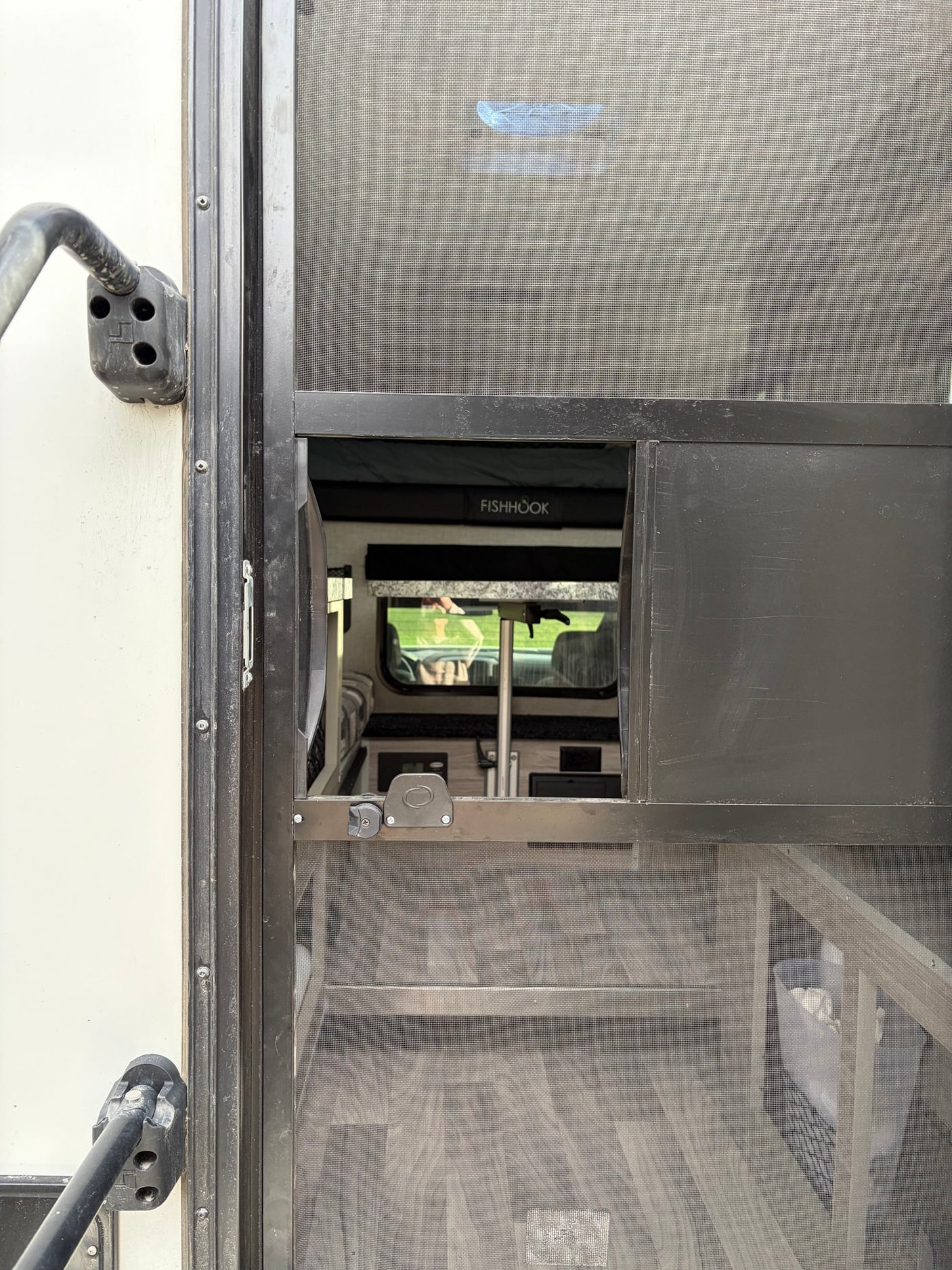 mountainous landscape.|Explore snowy Alaska in this Chevy Silverado rv rental with a gray FISHHOOK truck camper. Ideal for your next outdoor adventure!|Rear view of a FISHHOOK truck camper on a pickup in snow. Its open door reveals the interior