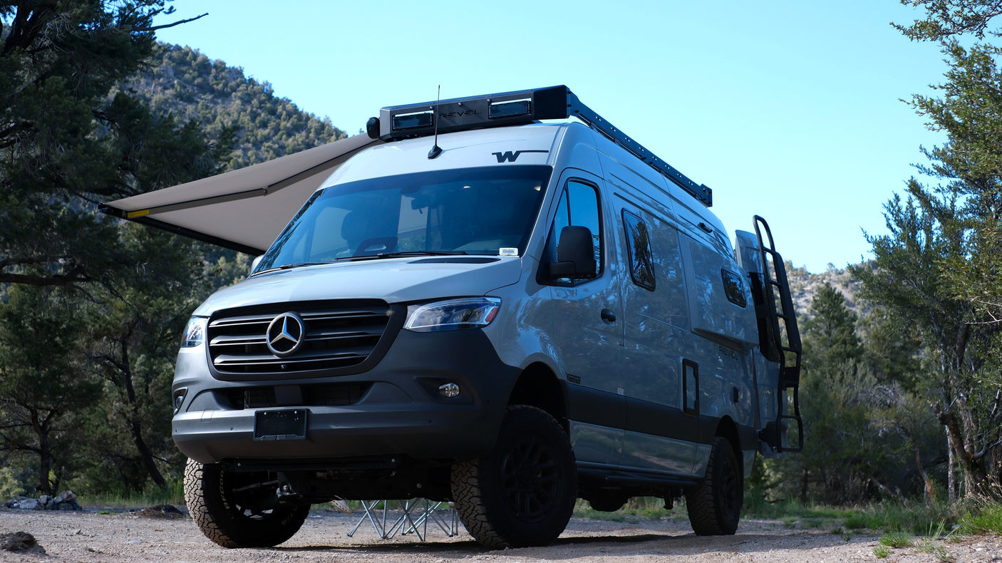 Winnebago Revel Mercedes Sprinter camper van, equipped with off-road tires & an awning, great for RV rental adventures.