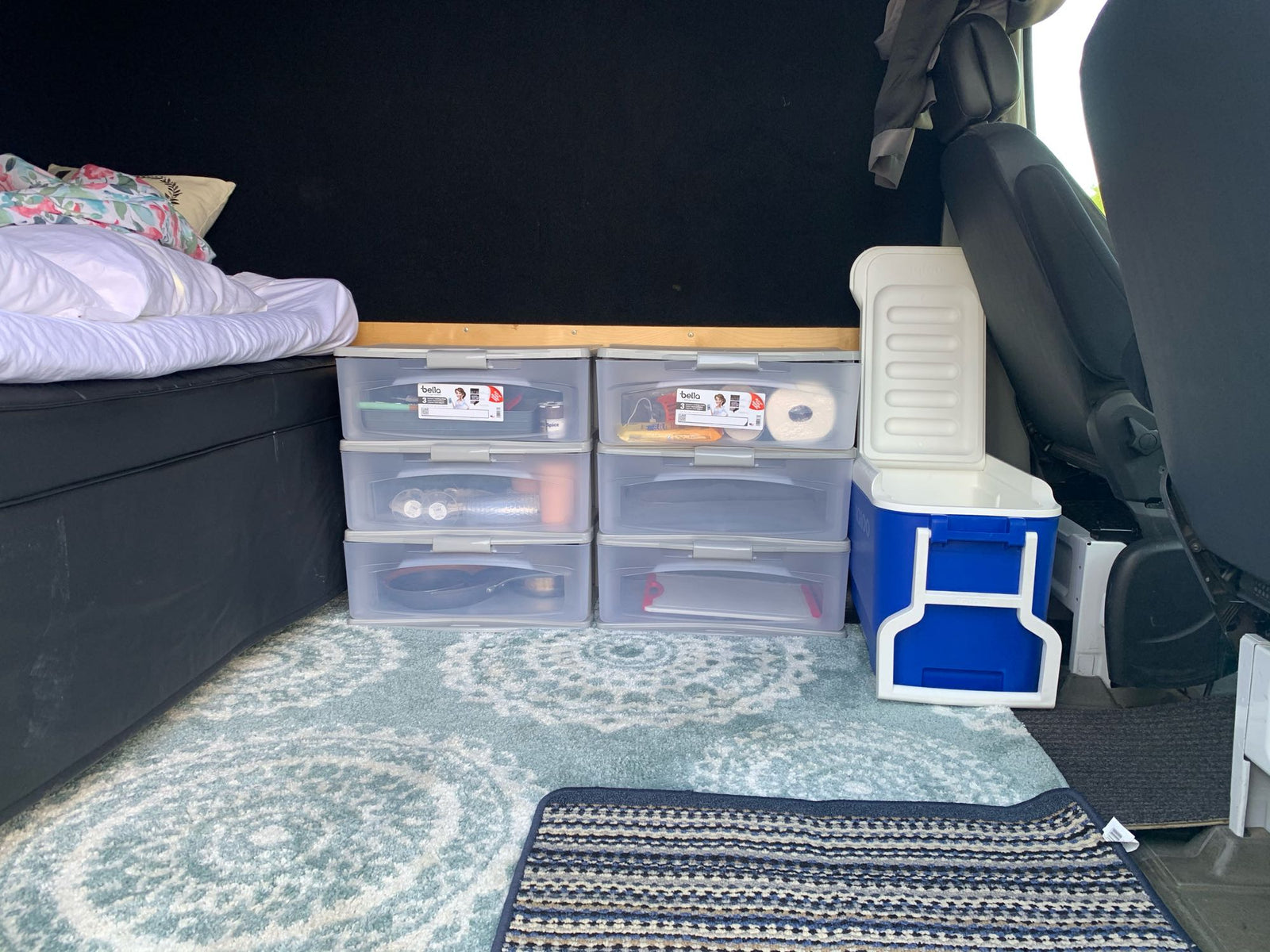 is parked lakeside with majestic snow-capped mountains in Alaska.|White RV rental van by a scenic lake with snow-capped mountains. Ideal for vanlife adventures & road trips.|An organized RV rental interior with bed