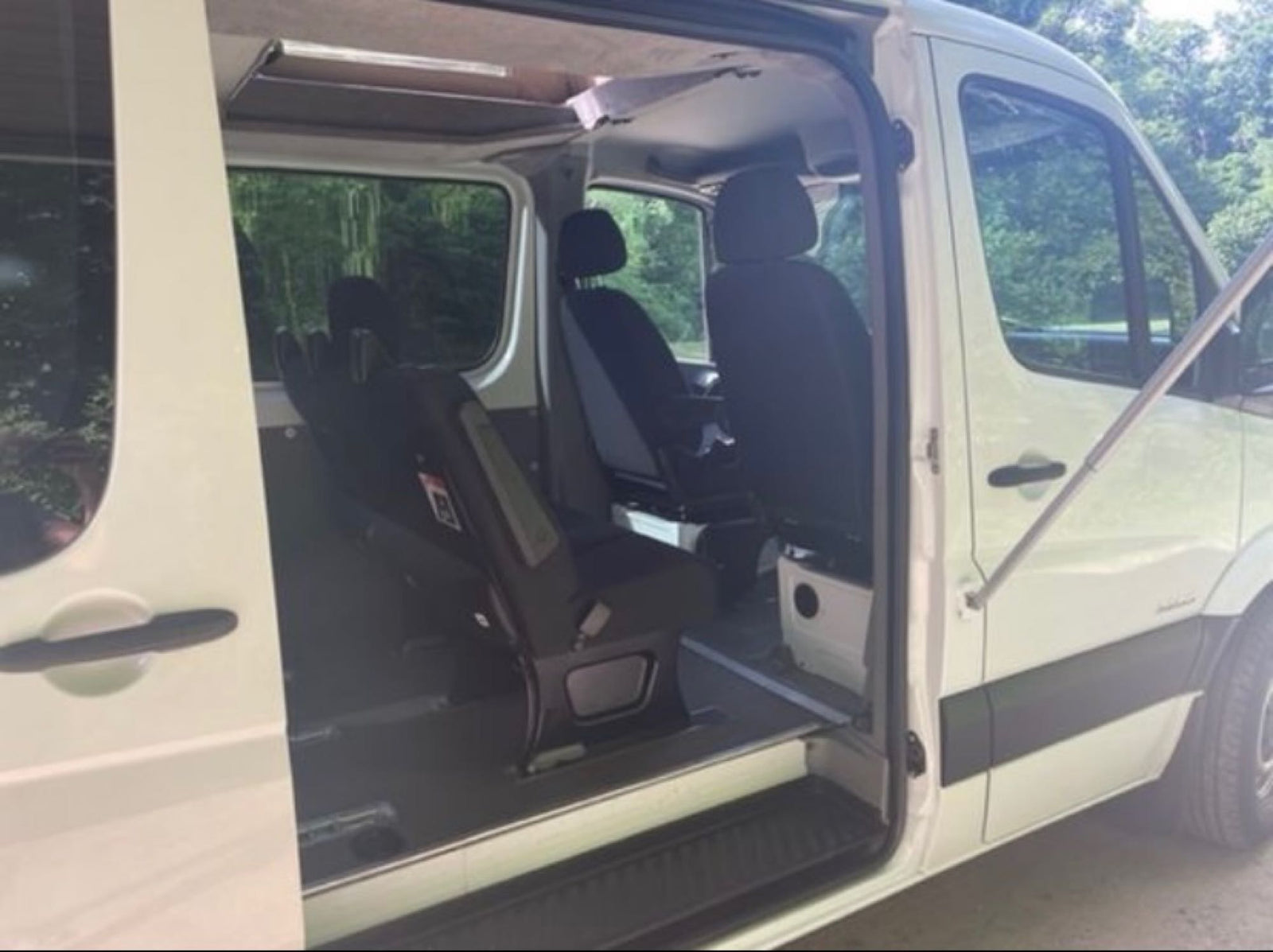 and overhead lights for comfortable travel.|White camper van with a raised pop-top tent