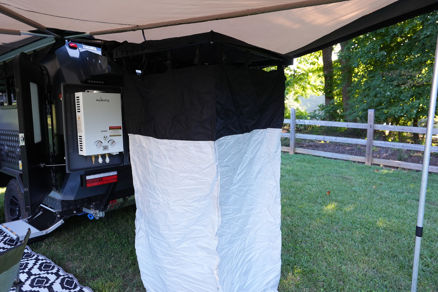 RV rental outdoor shower setup: Haobang water heater mounted on a travel trailer, with a privacy tent under the awning.